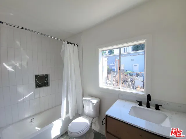 a bathroom with a sink a toilet a shower and a mirror