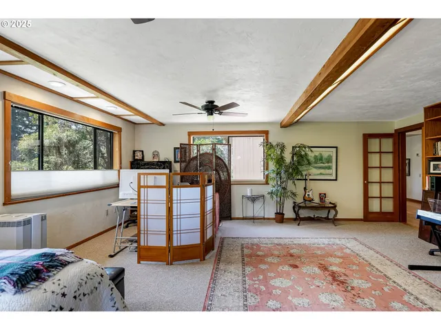 a bedroom with furniture and a large window