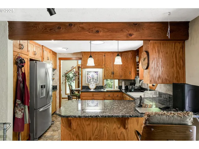 a kitchen with stainless steel appliances kitchen island granite countertop a sink and cabinets