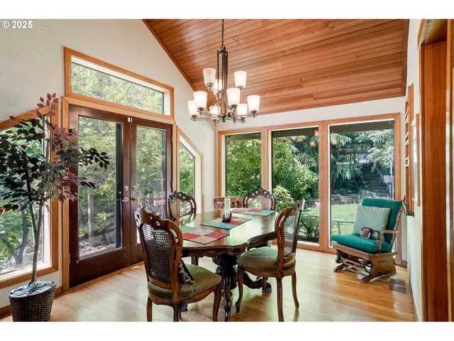 a dining room with furniture a chandelier and wooden floor