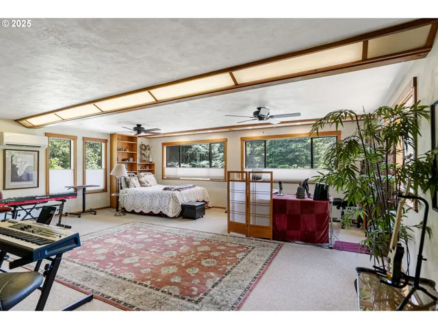 a living room with furniture a rug and a floor to ceiling window