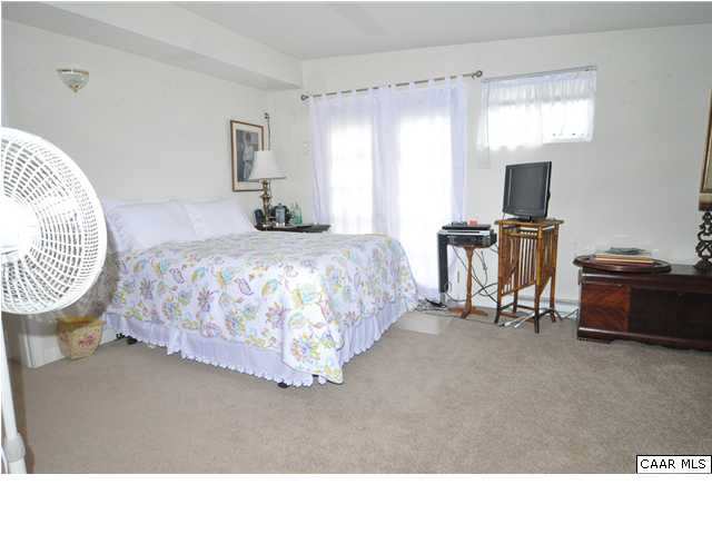 3425 Richmond Road Keswick, VA 22947 - Photo 16 of 22 a bedroom with a bed and a chandelier