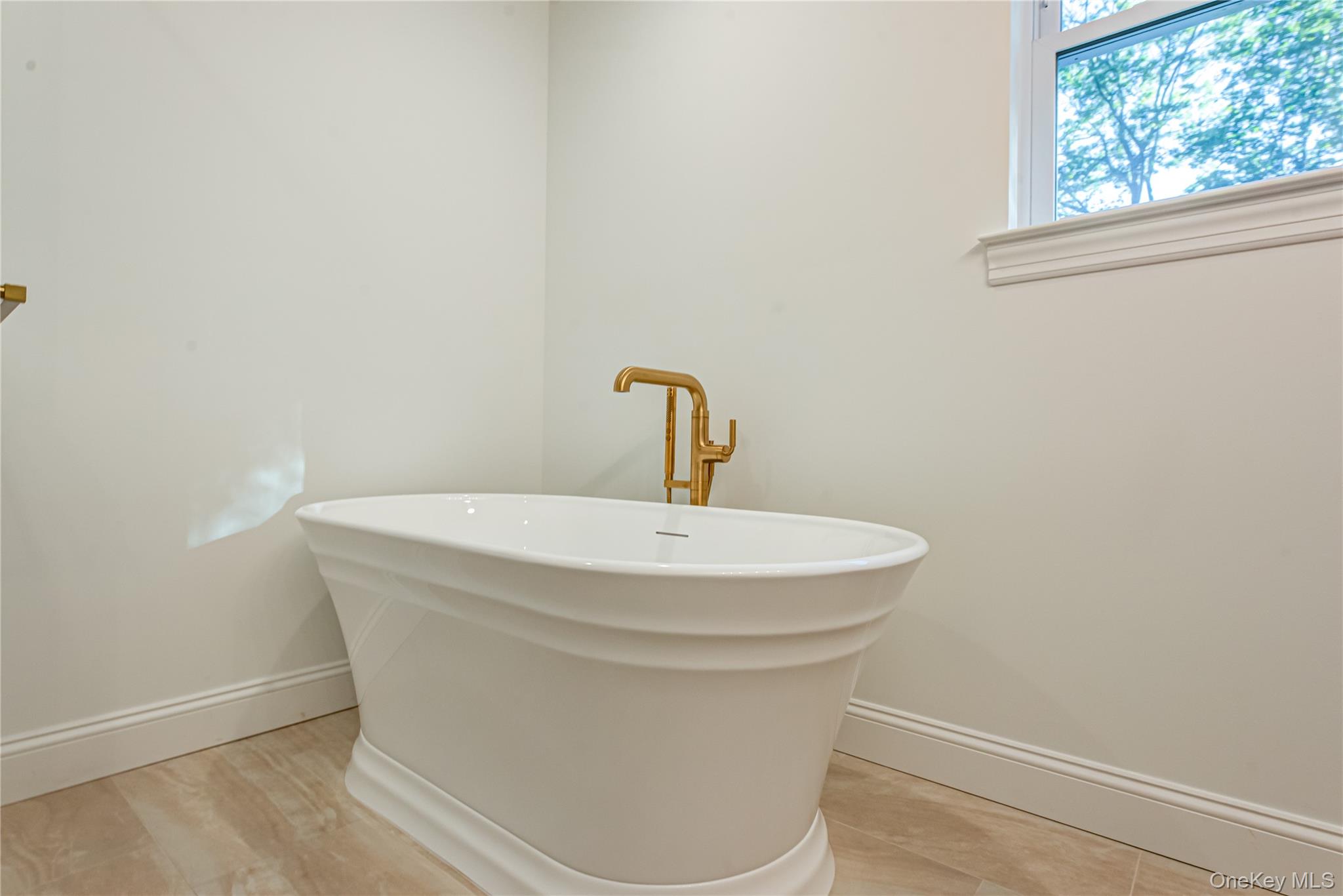 64 Blydenburgh Road Centereach, NY 11720 - Photo 38 of 44 Full bath with baseboards and a freestanding bath. . For Marketing Purposes!