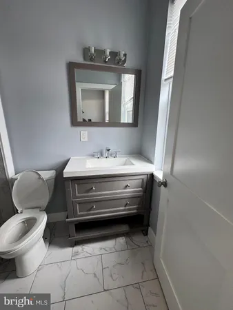 a bathroom with a toilet sink and mirror
