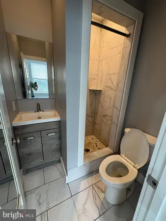 a bathroom with a toilet a sink and mirror