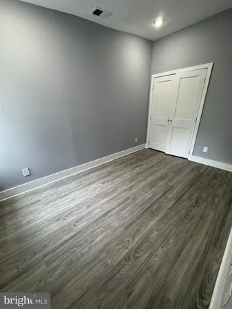 an empty room with wooden floor and cabinet