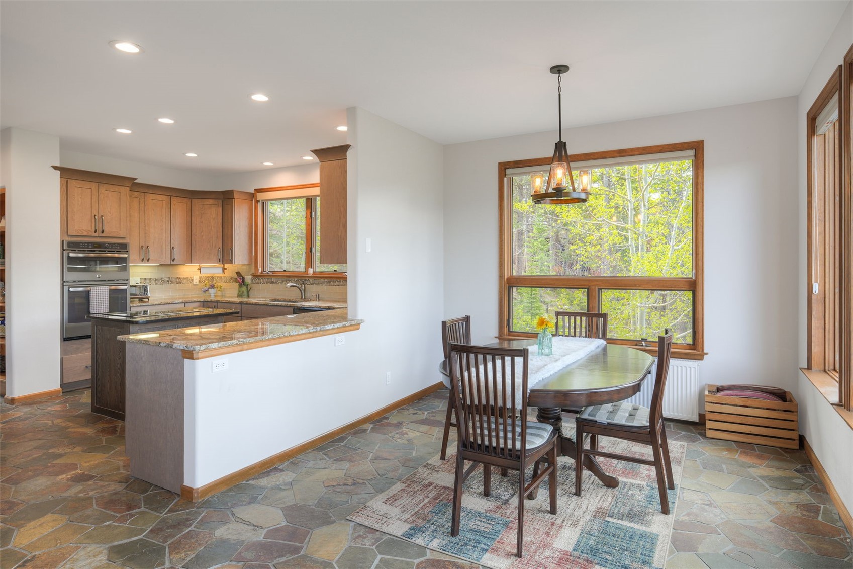 2542 Boreas Pass Road Breckenridge, CO 80424 - Photo 13 of 33 a kitchen with kitchen island granite countertop wooden cabinets and a dining table