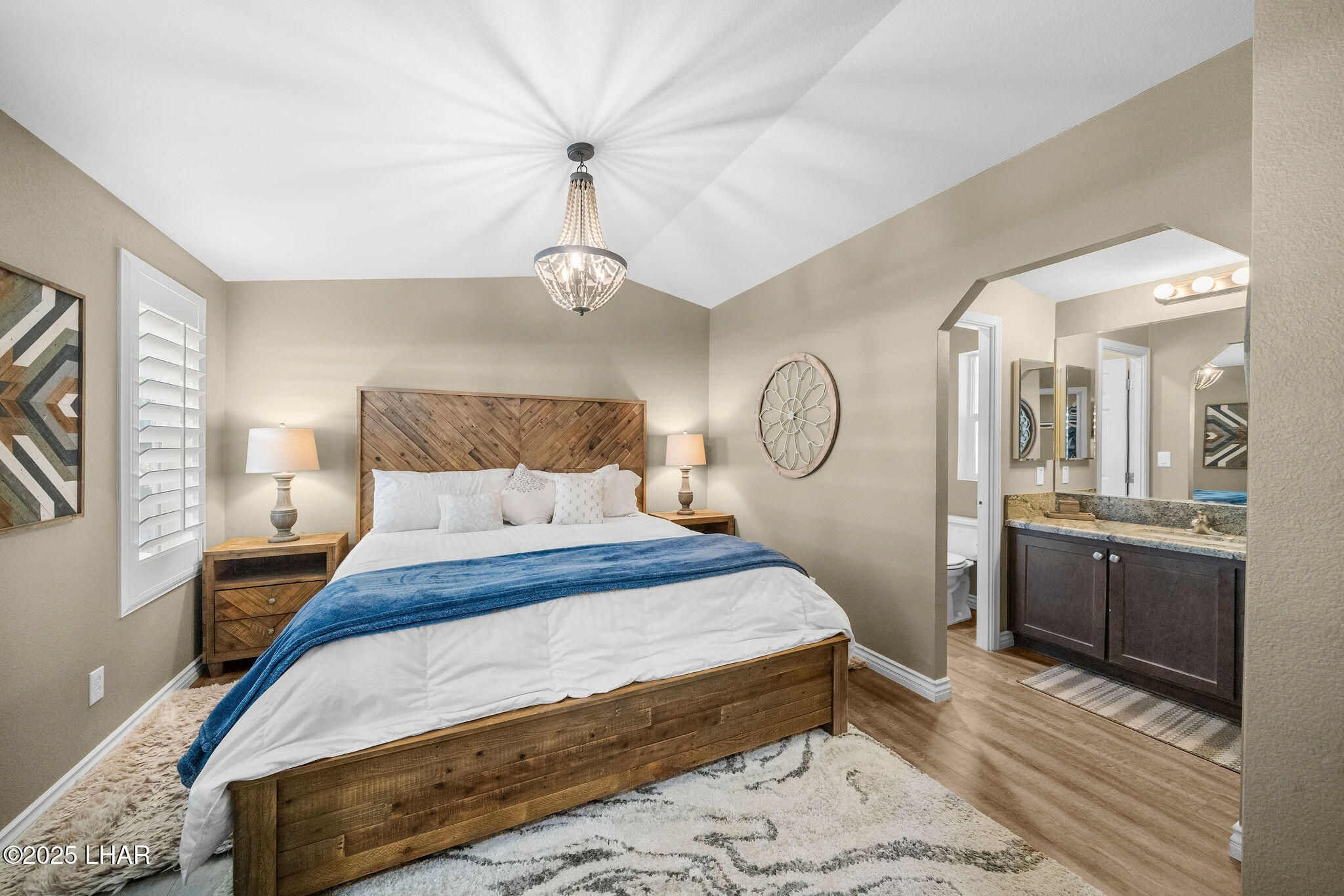 3020 Parker Dam Road, Unit 11 Parker, AZ 85344 - Photo 23 of 58 a bedroom with a large bed and a chandelier