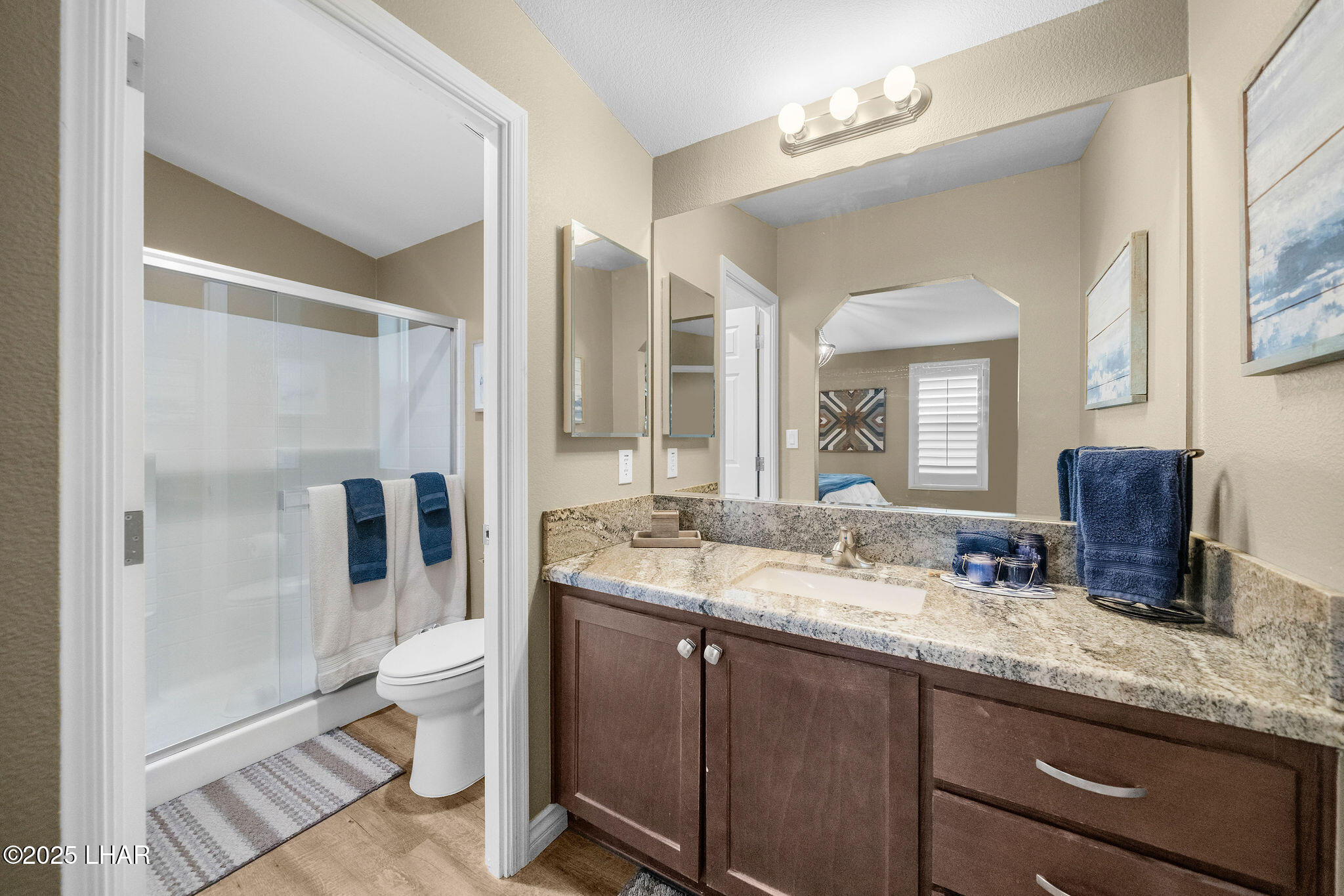 3020 Parker Dam Road, Unit 11 Parker, AZ 85344 - Photo 25 of 58 a bathroom with a granite countertop sink a toilet a mirror and shower