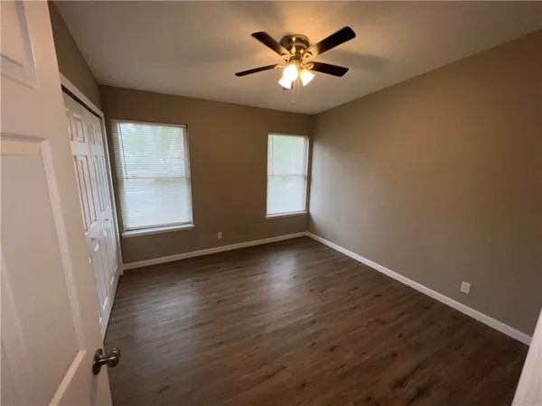 an empty room with wooden floor and window