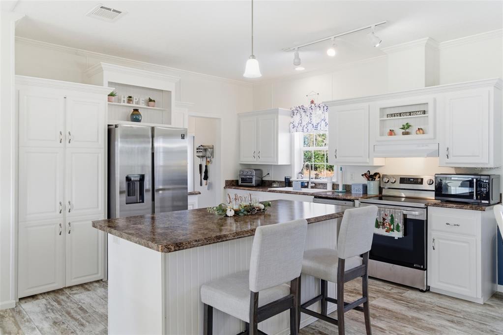 12441 Hexam Road Weeki Wachee, FL 34614 - Photo 14 of 46 a kitchen with stainless steel appliances granite countertop a kitchen island hardwood floor sink and stove