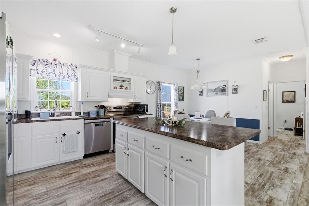 12441 Hexam Road Weeki Wachee, FL 34614 - Photo 17 of 46 a kitchen with granite countertop a sink a center island and cabinets