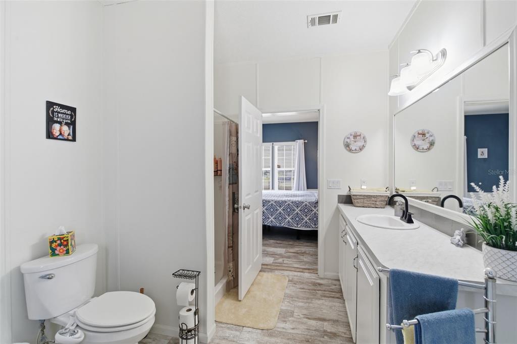 12441 Hexam Road Weeki Wachee, FL 34614 - Photo 27 of 46 a en suite bathroom with a granite countertop sink mirror vanity and toilet