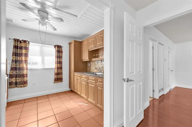 a view of a hallway to an empty room with a fireplace and a window
