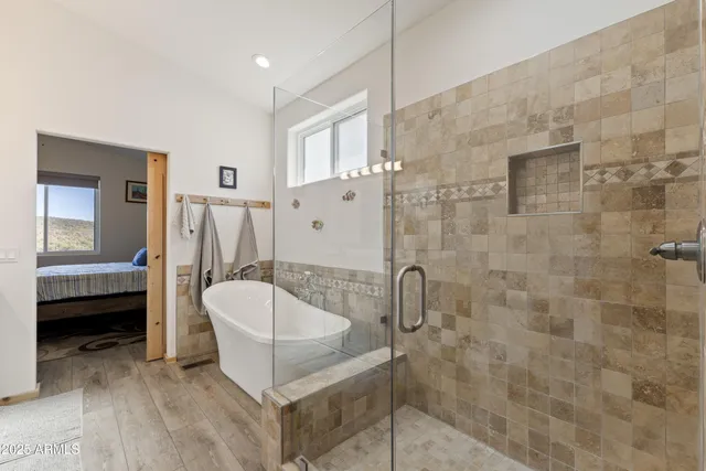 a spacious bathroom with a tub shower and mirror