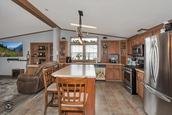 a kitchen with stainless steel appliances granite countertop a refrigerator a sink a stove and island