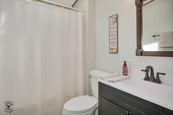 a white toilet sitting next to a shower curtain