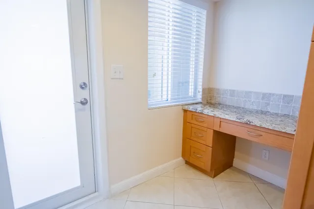 a view of kitchen with granite countertop cabinets and window