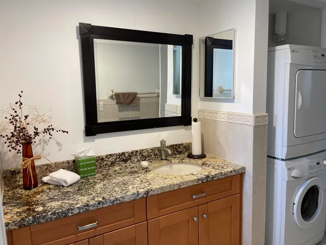a bathroom with a granite countertop sink and a mirror