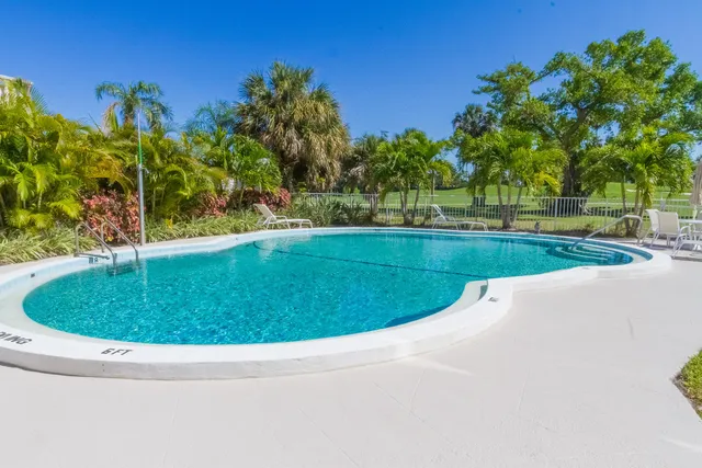 a view of a swimming pool and trees in the background