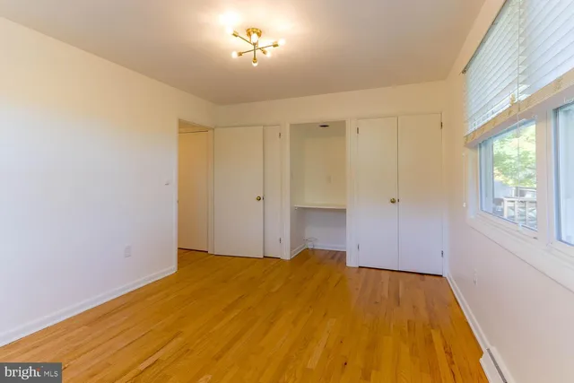 a view of empty room with a window and wooden floor
