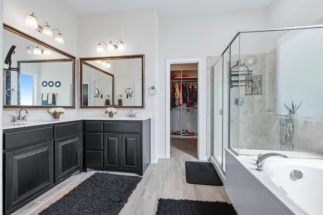 a spacious bathroom with a tub sink shower and mirror