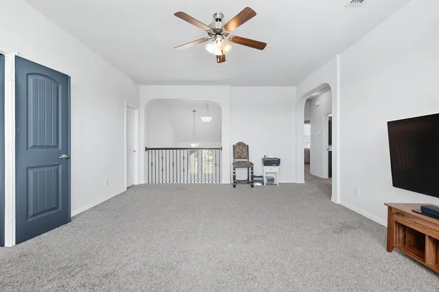a view of a livingroom with a flat screen tv and ceiling fan