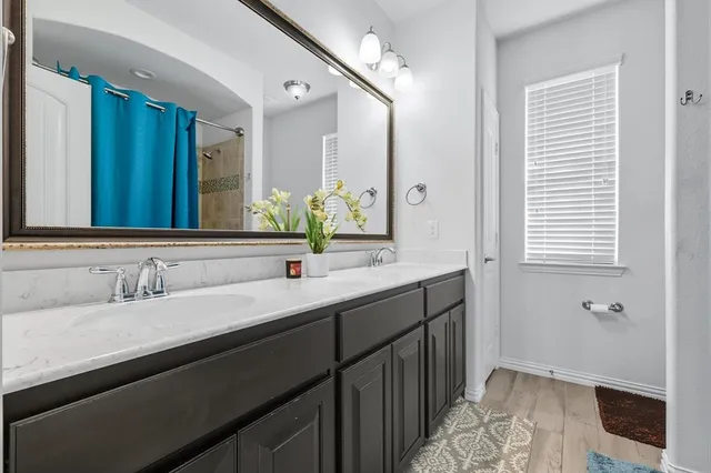 a bathroom with a double vanity sink and a mirror