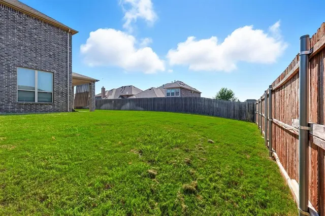 a view of a house with a big yard and large trees