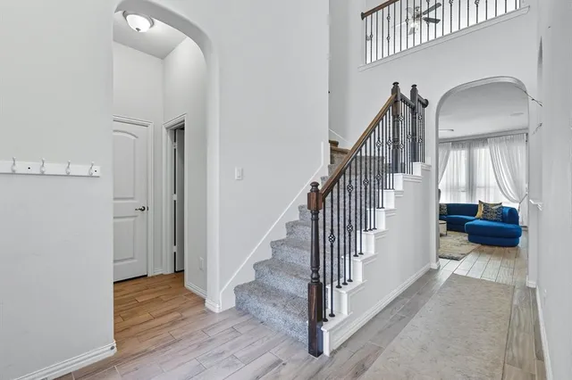 a view of a livingroom with wooden floor and stairs