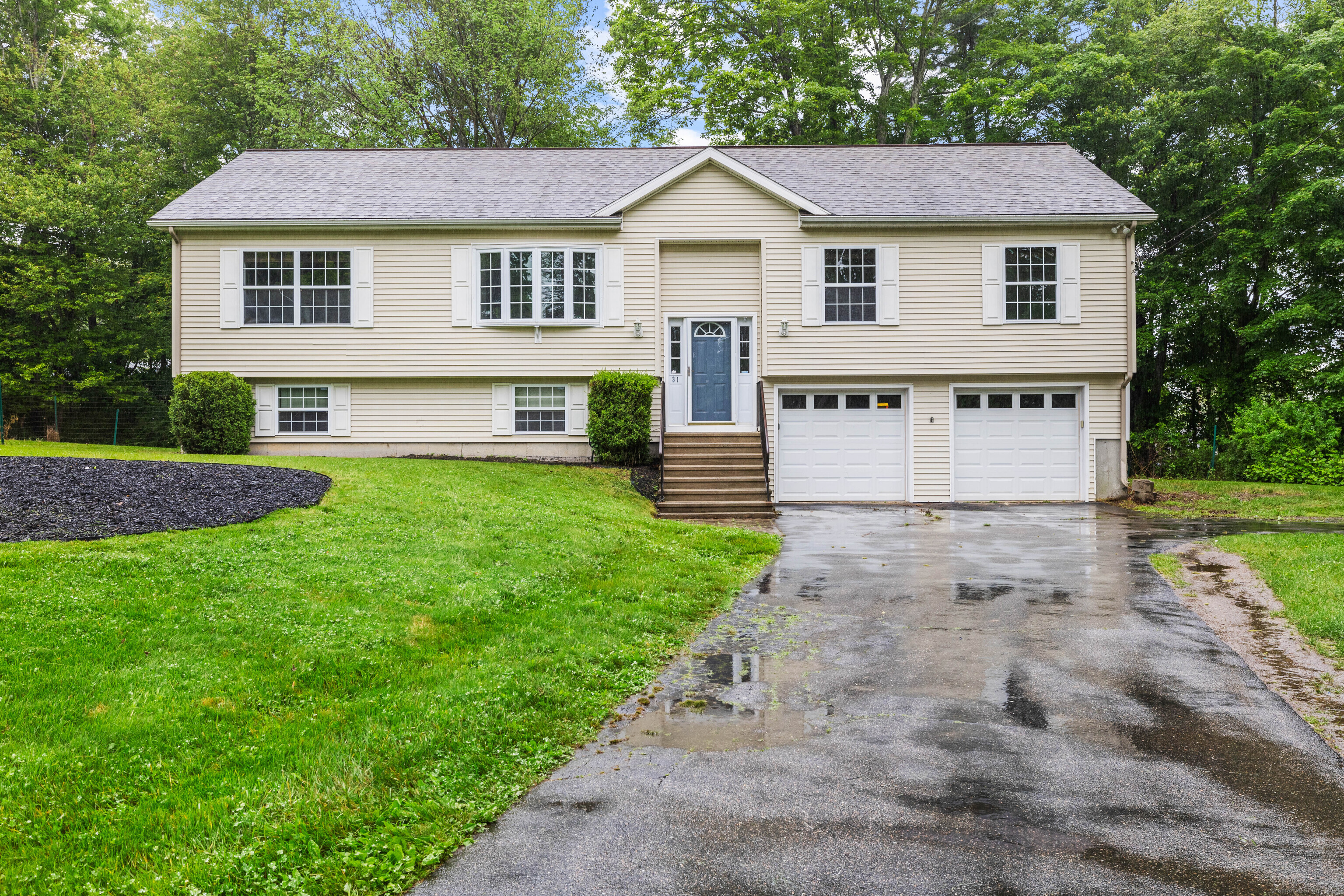 a view of a yard in front of a house with large windows
