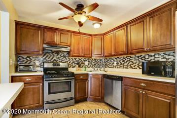 503 Harding Road, Unit 6 Freehold, NJ 07728 - Photo 12 of 23 a kitchen with stainless steel appliances a stove sink microwave and cabinets