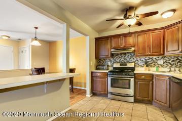 503 Harding Road, Unit 6 Freehold, NJ 07728 - Photo 13 of 23 a kitchen with kitchen island granite countertop a sink cabinets and stainless steel appliances
