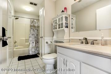 503 Harding Road, Unit 6 Freehold, NJ 07728 - Photo 21 of 23 a bathroom with a granite countertop sink toilet mirror and shower