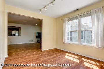 503 Harding Road, Unit 6 Freehold, NJ 07728 - Photo 9 of 23 a view of an empty room with wooden floor and a window