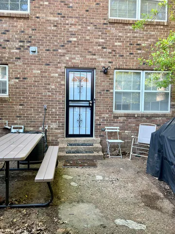 a brick house with table and chairs in front of it