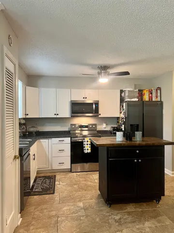 a kitchen with stainless steel appliances granite countertop a stove and a refrigerator