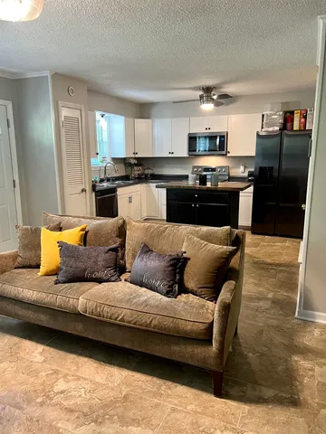 a living room with furniture and kitchen view