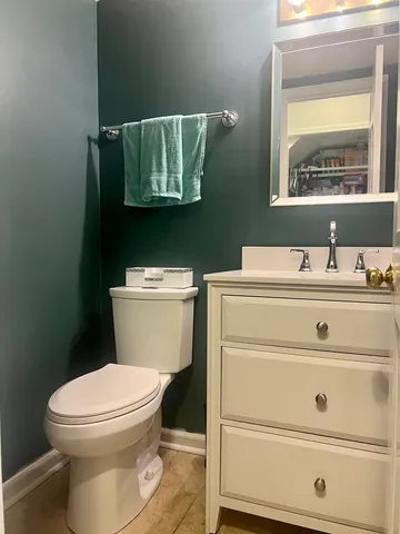 a bathroom with a toilet sink and mirror