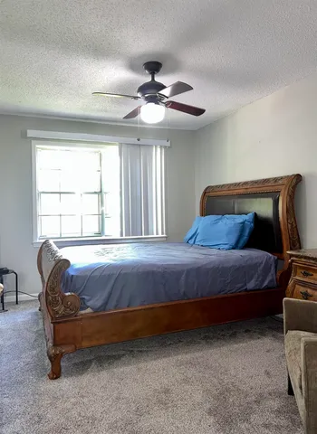 a bedroom with a bed and a ceiling fan