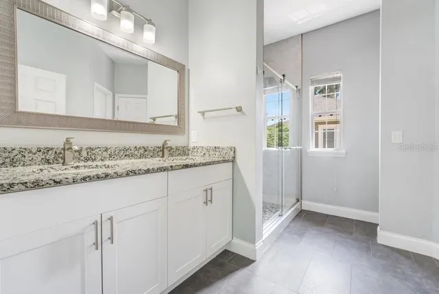 a bathroom with a granite countertop sink and a mirror