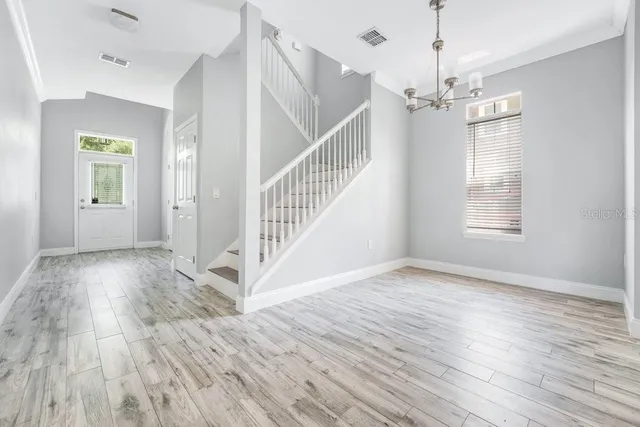 a view of empty room with wooden floor and window