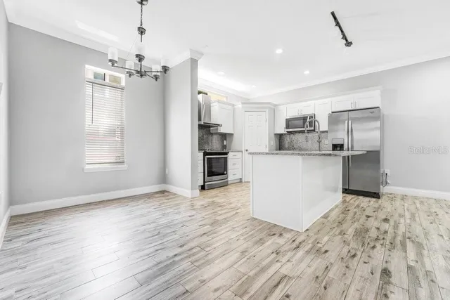 a view of kitchen with refrigerator microwave and wooden floor