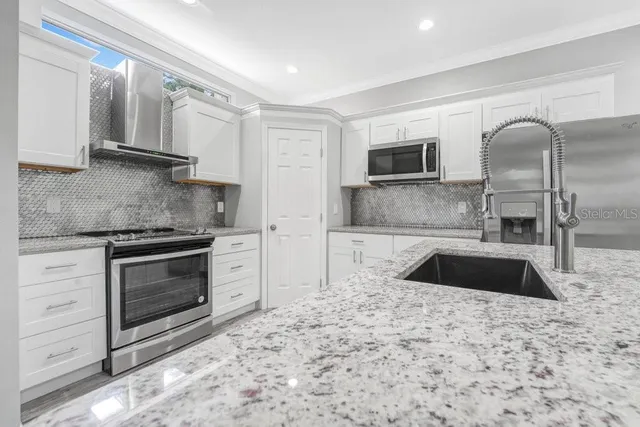 a kitchen with granite countertop a sink and a stove top oven