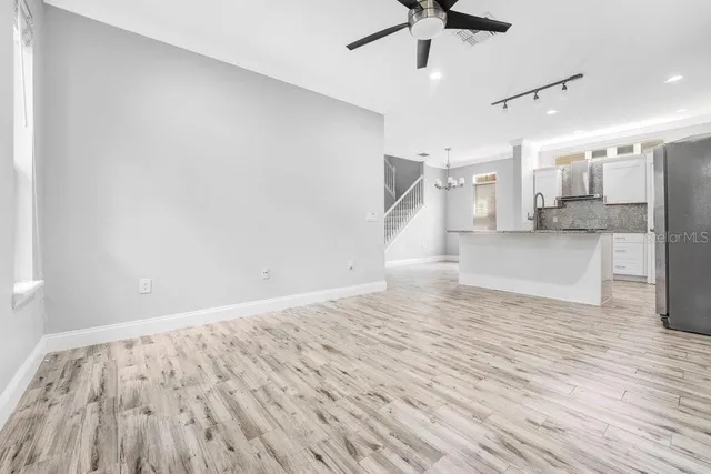a view of empty room with wooden floor