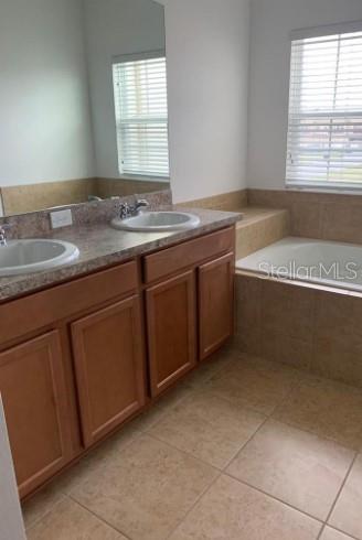 5706 Cypress Hill Road Winter Garden, FL 34787 - Photo 13 of 21 a bathroom with a granite countertop sink and a bathtub