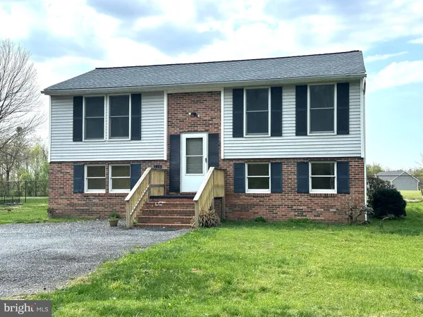 a view of house with backyard and outdoor seating
