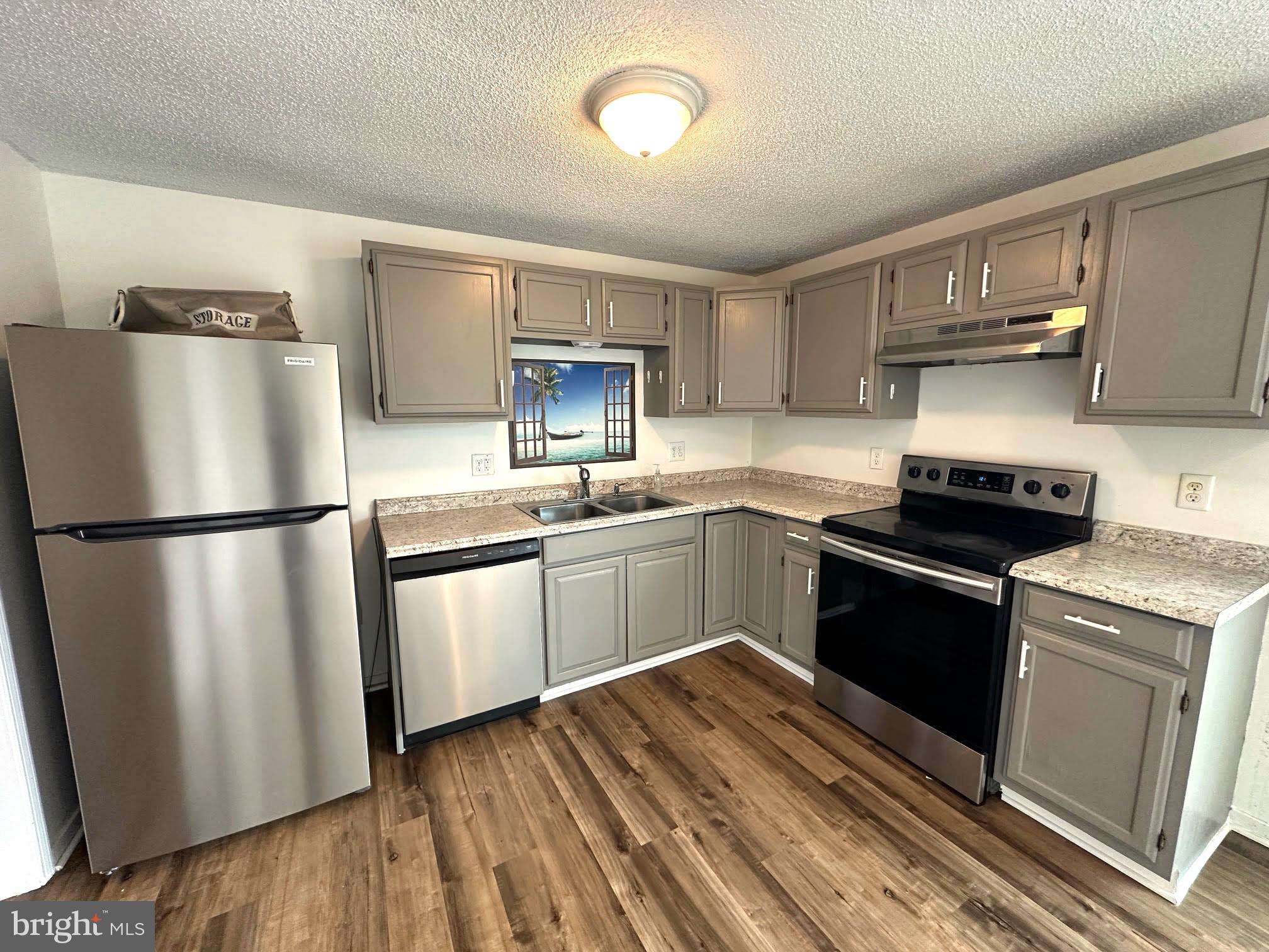 119 Cove Point Road Lusby, MD 20657 - Photo 8 of 22 a kitchen with granite countertop a refrigerator stove top oven and sink