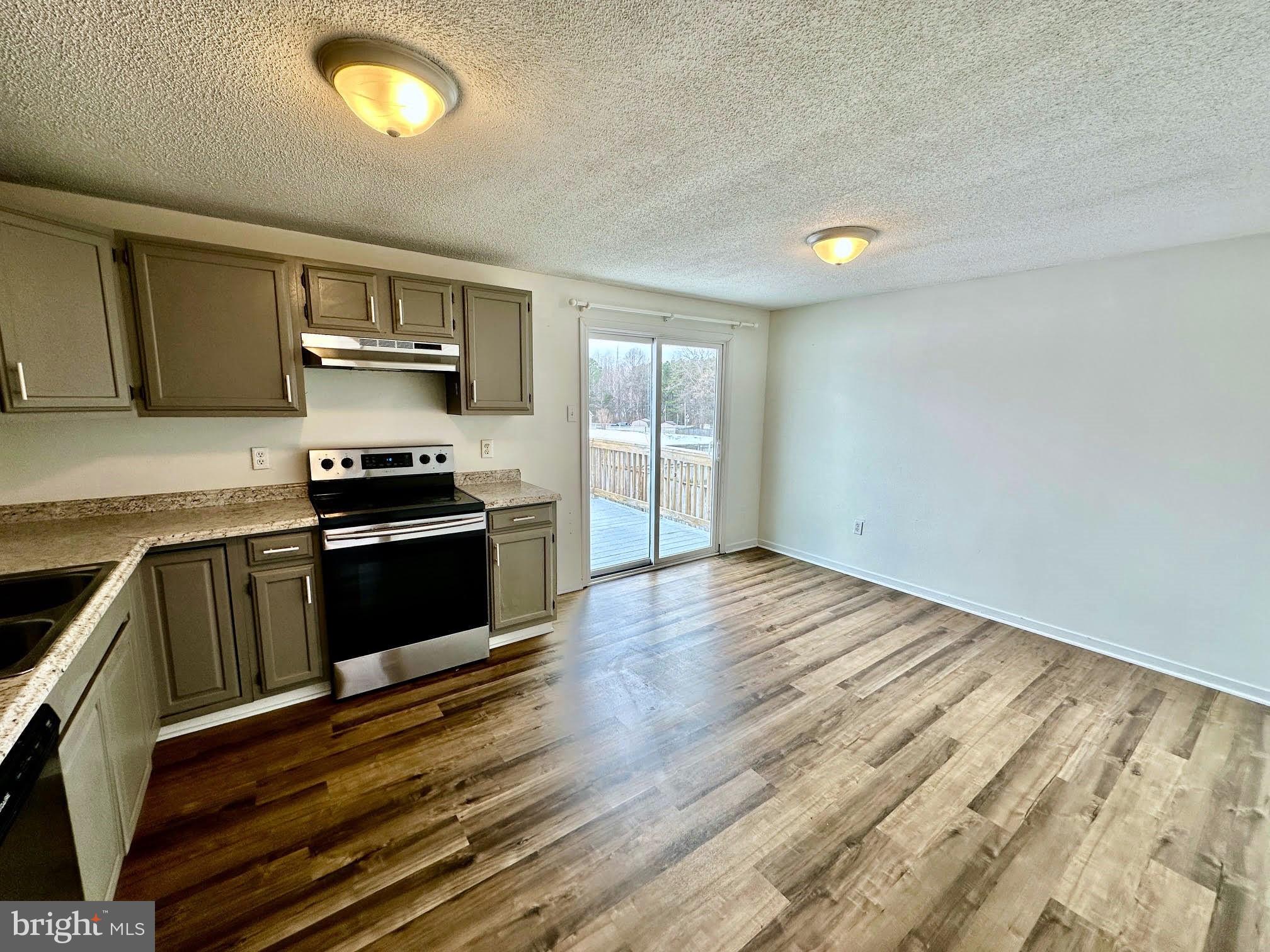 119 Cove Point Road Lusby, MD 20657 - Photo 9 of 22 a kitchen with wooden floors and black appliances