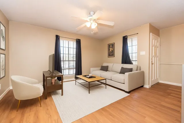 a living room with furniture and a wooden floor
